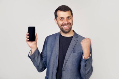 Akıllı telefon ekranında gururla bağıran ve başarıyı kutlayan genç adam 5G