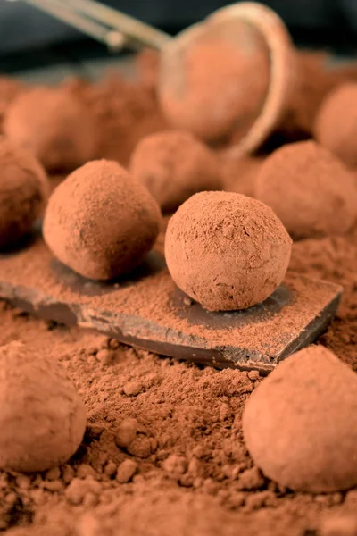 Chocolate truffles covered with cacao powder on a black plate