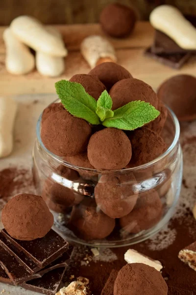 Chocolate truffles sprinkled with cocoa powder in a glass jar