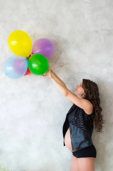 Zwangere vrouw met ballonnen in handen — Stockfoto