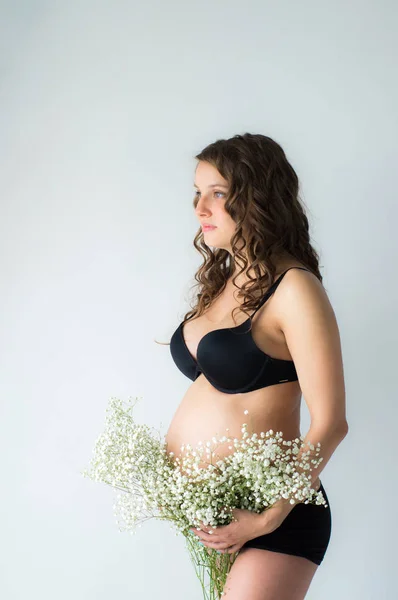Беременная женщина с букетом цветов в руках — стоковое фото