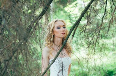 Ormanda dalların arasından genç sarışın gelinin portresi