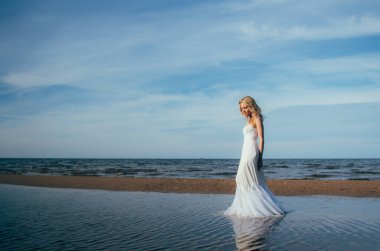 Suyun içinde yürüyen genç sarışın gelin portresi