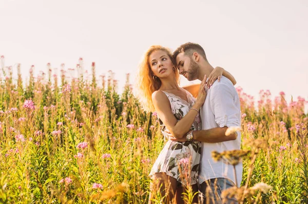 Молодой человек обнимает свою девушку в поле — стоковое фото