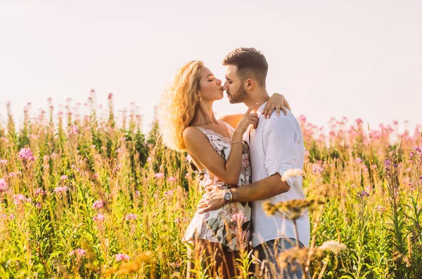 Jovem abraçando e beijando sua namorada no campo — Fotografia de Stock