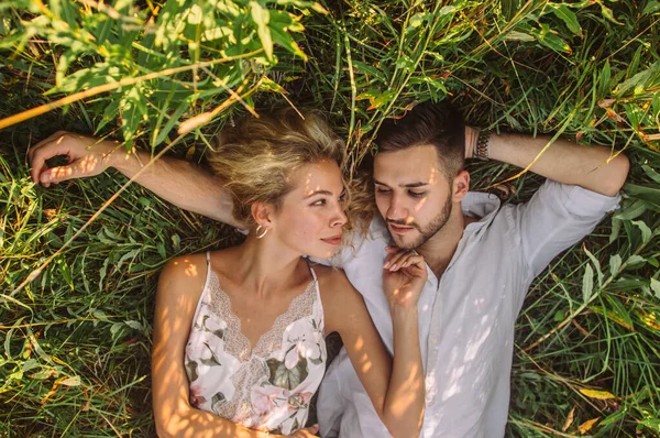 Jeune homme et jeune femme couchés ensemble sur le terrain — Photo