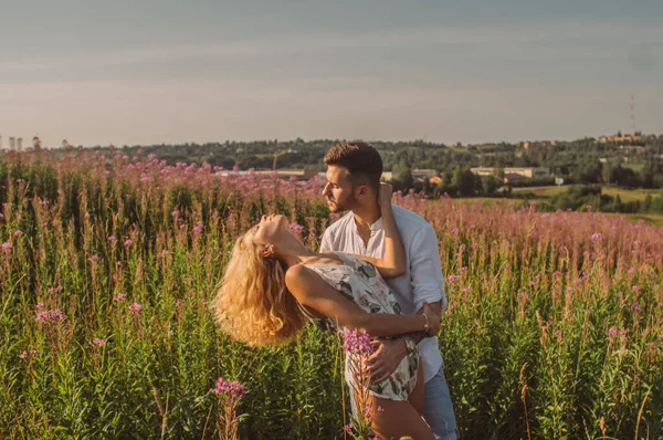 Joven hombre y mujer juntos en el campo, mujer con arrojado hacia atrás — Foto de Stock