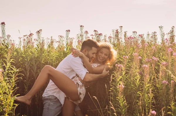 Young man and woman fool around in the field — Stock Photo, Image