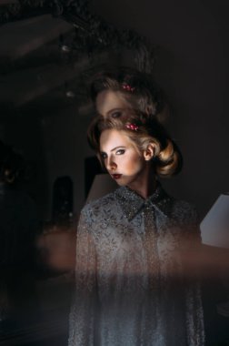 Kaliteli makyajlı güzel sarışın kız ve kameraya birden fazla efektle bakan saç stili.