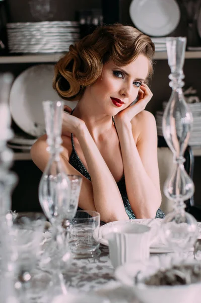 아름다운 금발의 소녀는 고전적 화장을 스타일을 저녁에는 탁자에 접시와 안경을 로열티 프리 스톡 이미지