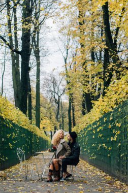 Koridorun ortasında oturan ve kucaklaşan çift elinde kırmızı bir gül tutuyor.