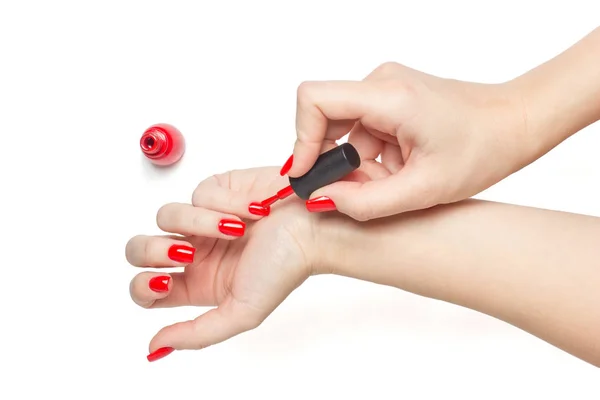 Mujer aplicando esmalte de uñas rojo sus uñas manicura sobre fondo blanco aislado — Foto de Stock