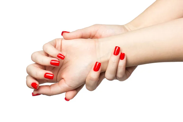 Primer plano de las manos de una mujer joven con las uñas largas de color rojo manicura sobre fondo blanco — Foto de Stock