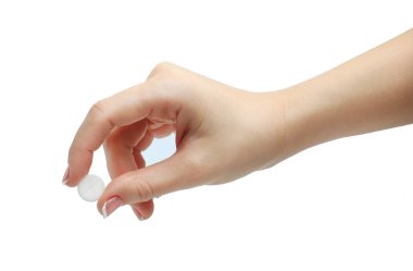 Bir hap başparmak ve işaret parmağı beyaz arka plan üzerinde izole arasında tutan el. manikürlü elini