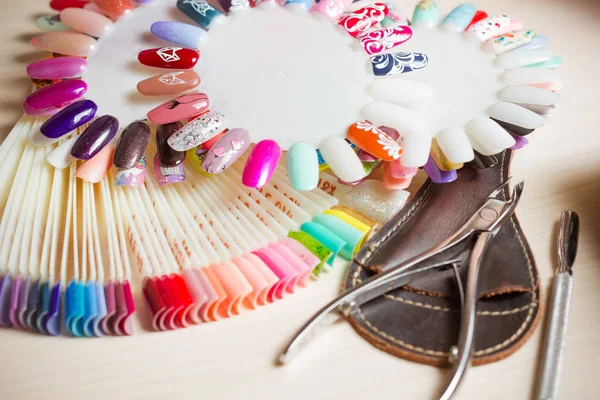 Tafel vol met manicure gebruiksvoorwerpen, manicure gereedschappen, nagellak kleuren op het palet. Nagels kunst accessoires — Stockfoto