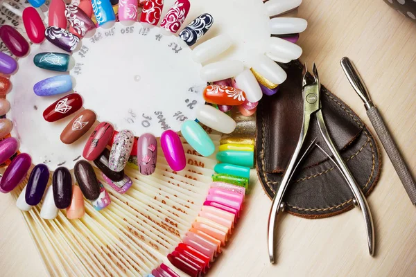 Tafel vol met manicure gebruiksvoorwerpen, manicure extra, nagellak kleuren op palet. Nagels kunst accessoires. Bovenaanzicht — Stockfoto