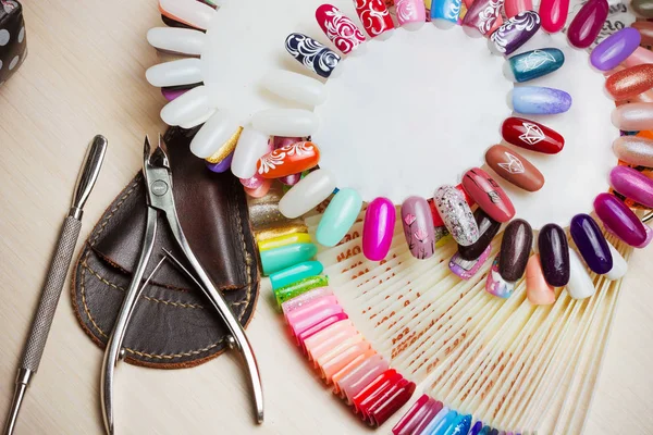 Tafel vol met manicure gebruiksvoorwerpen, manicure extra, nagellak kleuren op palet. Nagels kunst accessoires. Bovenaanzicht — Stockfoto