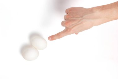 El yumurta beyaz bir arka plan üzerine işaret ediyor
