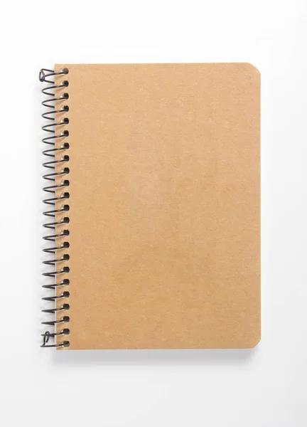 Bovenaanzicht van gesloten spiraal blanco gerecycled papieren omslag notebook op witte bureau achtergrond — Stockfoto