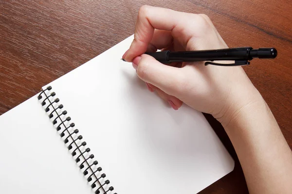 Caderno e caneta na mão. Isolado sobre fundo branco . — Fotografia de Stock