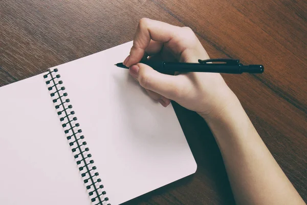 Caderno e caneta na mão. Isolado sobre fundo branco . — Fotografia de Stock