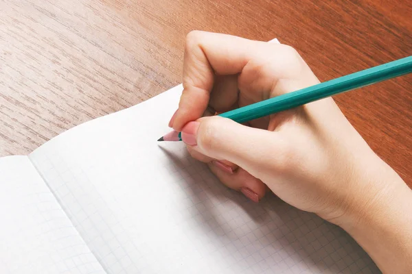 Närbild foto av flicka skriver i anteckningsbok med penna — Stockfoto