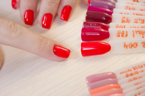 Bovenaanzicht vrouw selecteert gele kleur schellak nagellak. Nagel technicus toont het kleurenpalet van de diensten van de nagel in de beauty salon. — Stockfoto