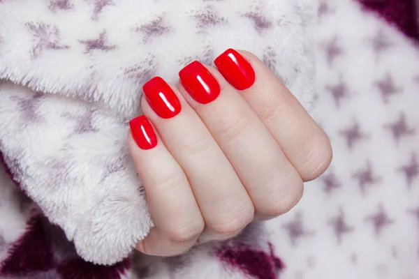 Red manicure. Hand in a warm blanket. wool Shaggy background — Stock Photo, Image