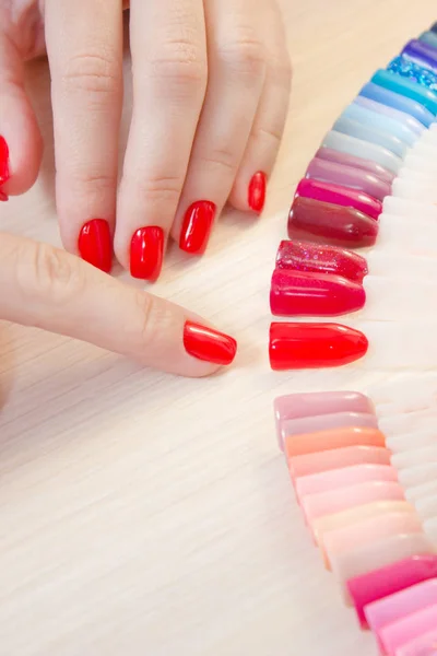 Top view woman selects yellow color shellac nail polish.Nail technician shows the color palette of nail services in beauty salon. — Stock Photo, Image