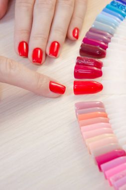 Üstten Görünüm kadın sarı renk shellac oje seçer. Tırnak teknisyeni tırnak Hizmetleri renk paletinin güzellik salonunda gösterir..