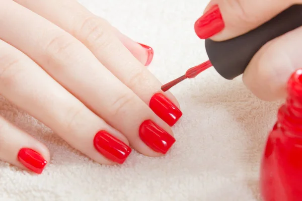 Manicure - prachtig gemanicuurde nagels van de vrouw met rode nagellak op zachte witte handdoek. — Stockfoto