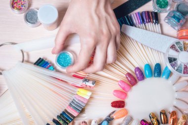 Tırnak sanat kavramı. Beyaz masa üzerinde çivi dekorasyon yapma kadın
