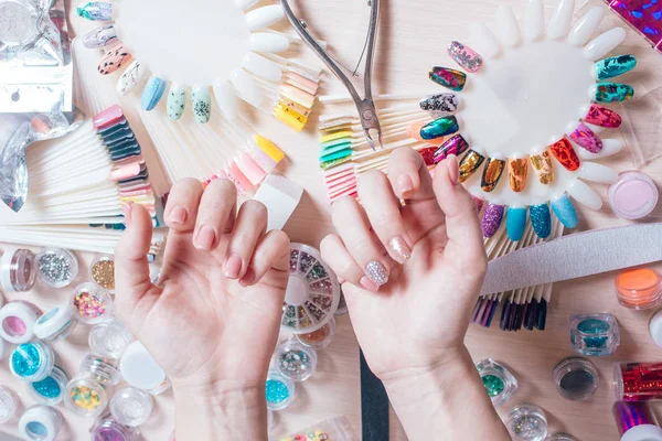 Nail art concept. Vrouw decoratie op de nagels op witte tafel maken — Stockfoto