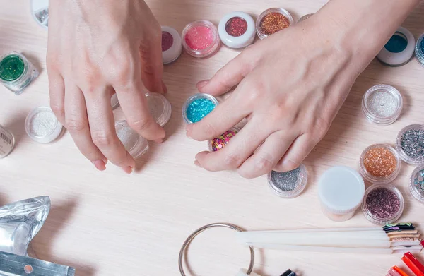 Verzorgde vrouw handen prepeared werk met decoraties voor nagels design — Stockfoto