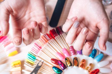 Tırnak sanat kavramı. Beyaz masa üzerinde çivi dekorasyon yapma kadın