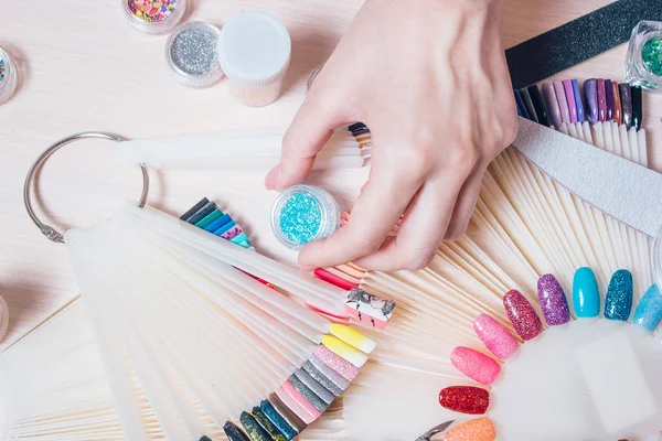 Nail art concept. Vrouw decoratie op de nagels op witte tafel maken — Stockfoto