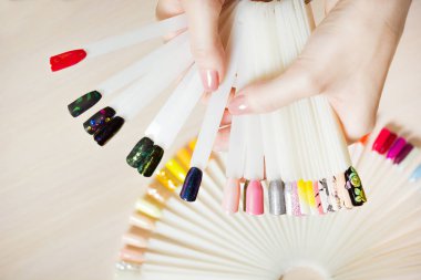 Üstten Görünüm kadın sarı renk shellac oje seçer. Tırnak teknisyeni tırnak Hizmetleri renk paletinin güzellik salonunda gösterir..