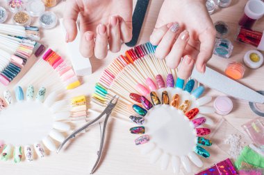 Tırnak sanat kavramı. Beyaz masa üzerinde çivi dekorasyon yapma kadın