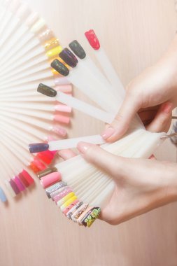 Üstten Görünüm kadın manikür Renkli oje seçin. Tırnak teknisyeni tırnak Hizmetleri renk paletinin Güzellik Salonu deposunda gösterir. Spa uygulamaları. Güzellik ve moda kavramı.