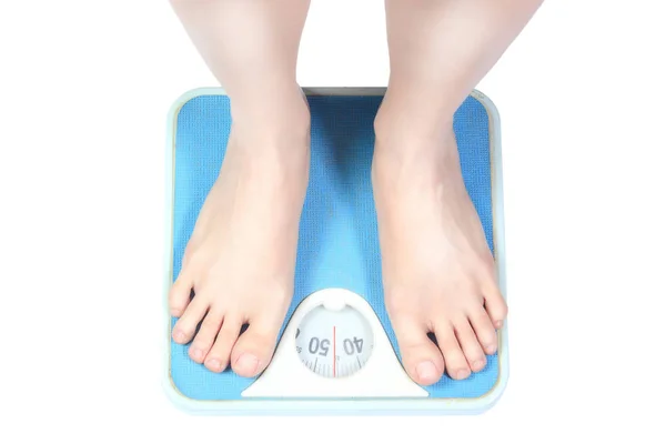 Bare female feet standing on bathroom scale — Stock Photo, Image