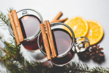 Narenciye ile mulled şarap sıcak içecek ve baharatlar cam Kupası ve beton zemin çam dalı