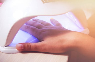 UV lamba jel manikür sürecinde bir güzellik salonu aletleri. Salon yordamı. Işık sızıntıları ile