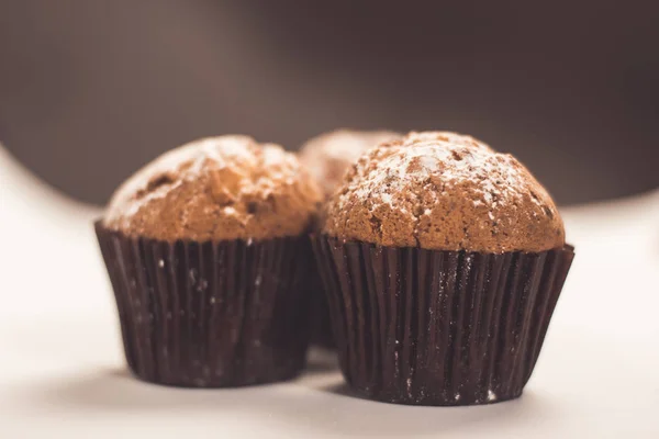 Σπιτικά muffins σοκολάτας whith ζάχαρη σε σκόνη που απομονώνονται σε λευκό, επιλεκτική εστίαση — Φωτογραφία Αρχείου