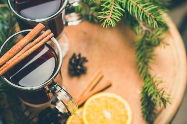 Narenciye ile mulled şarap sıcak içecek ve baharatlar cam Kupası ve beton zemin çam dalı