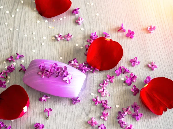 Beyaz ahşap masa üzerinde Eflatun çiçekli sabunlar