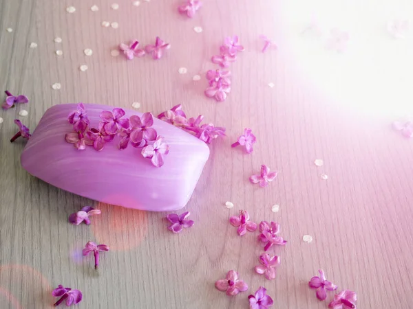 Beyaz ahşap masa üzerinde Eflatun çiçekli sabunlar
