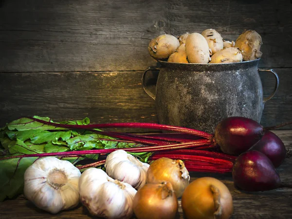 Bir eski pot patates soğan sarımsak pancar eski tahta arka plan üzerinde