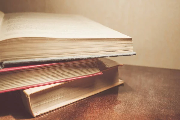 Renkli kapaklı kitap yığını. Kitaplık veya kitapçı. Kitap veya ders kitapları. Ön planda açık kitap.