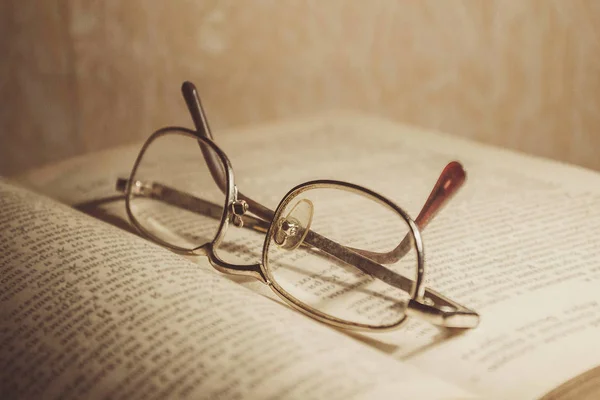 Glasses on the book. A stack of books with colorful covers. The library or bookstore. Books or textbooks. Education and reading.