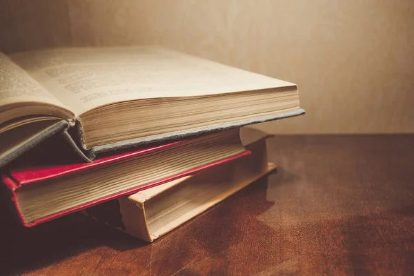 Renkli kapaklı kitap yığını. Kitaplık veya kitapçı. Kitap veya ders kitapları. Ön planda açık kitap.